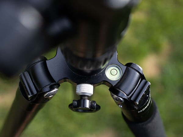Black camera tripod with glass circular bubble level vial
