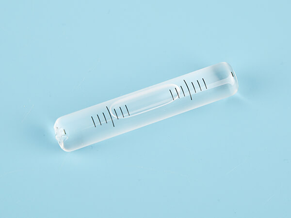 Glass tubular bubble level with scales on a frosted surface without a tip.