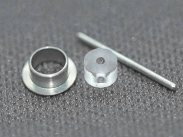 Components of hermetic glass-to-metal seal on blue cloth.